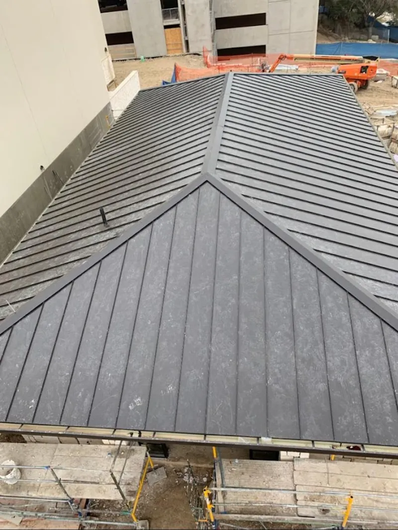 Commercial metal roof construction with crane equipment in Rockville Centre